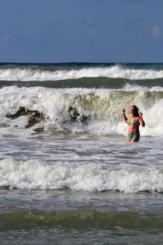 The woman in the sea against big waves