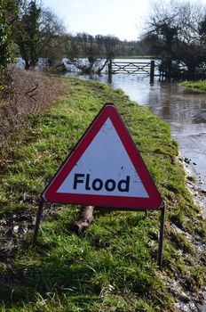 Traffic warning sign informing road users of the road way being flooded.