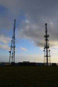 Two large communication masts on the Sussex hill of Firle Beacon.