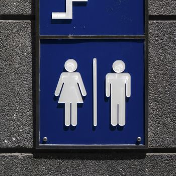 toilet sign on wall at public street