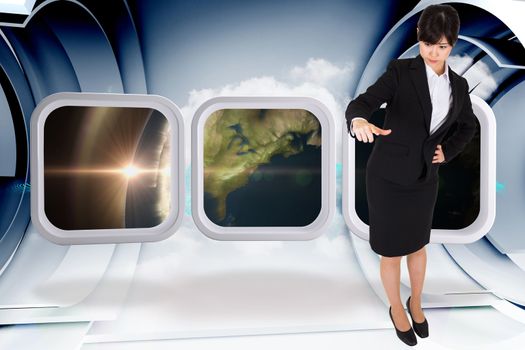 Businesswoman pointing against abstract blue cloud design in futuristic structure