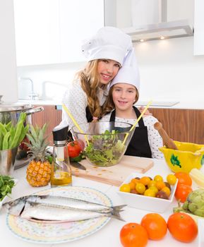 Kid girls junior chef friends hug together in countertop with food at cooking school