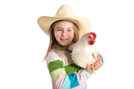 Blond kid girl farmer holding white hen on arms with cowboy hat