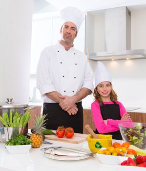 Chef master and junior pupil kid girl at cooking school with food on countertop