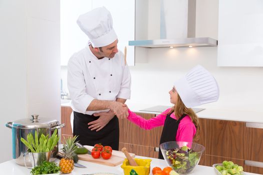 Chef master and junior pupil kid girl handshake at cooking school