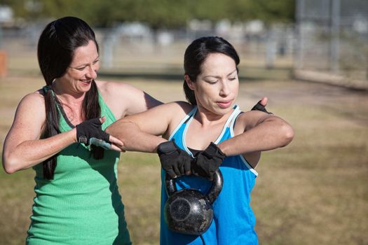 Two women working out with kettle bell weights