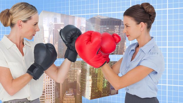 Businesswomen with boxing gloves fighting against blue background with grid