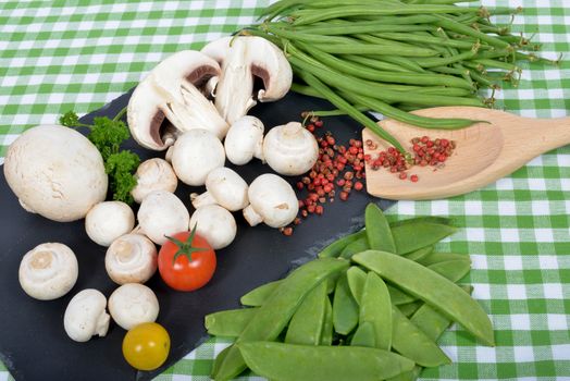 Paris mushrooms on a slate plate with peas and beans