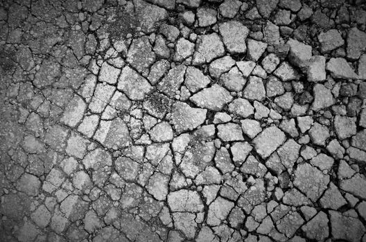 Old asphalt road with many dangerous cracks 