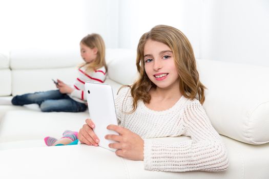 Children sister friends kid girls playing with tablet pc on white sofa