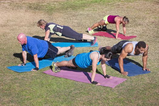Group of five people exercising in outdoor boot camp