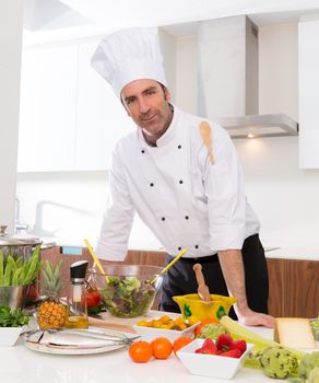 Chef male portrait on white countertop with food at kitchen