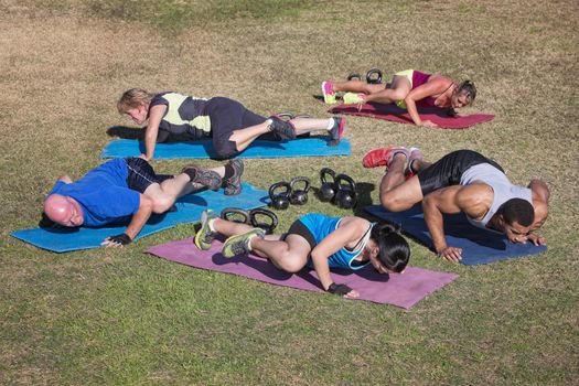 Group of five adults doing knee to elbow push-ups