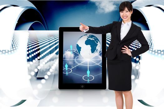 Smiling businesswoman pointing against abstract design in blue and white