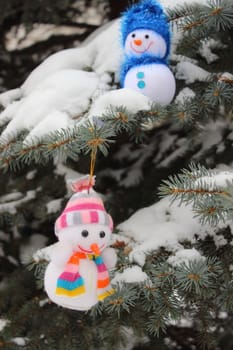 Bright cheerful Christmas Snowmen on a snowy tree lie