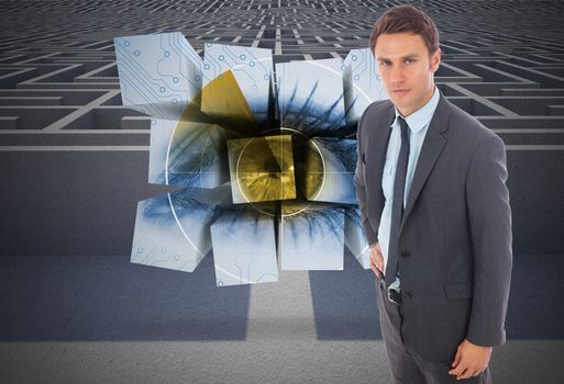 Serious businessman standing with hand on hip against entrance to difficult maze puzzle