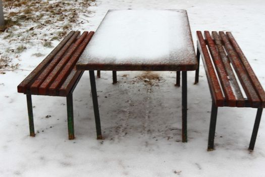 Wooden table and benches in the snow