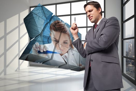 Thoughtful businessman holding pen against room with large window showing city