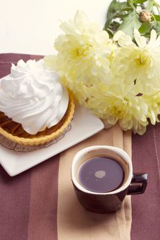 Coffee and cake with whipped cream near chrysanthemums