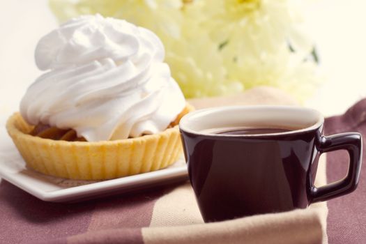 Coffee and cake with whipped cream near chrysanthemums