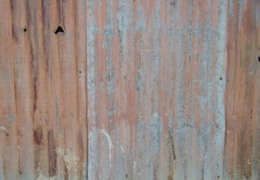 An abstract background image of rusty corrugated iron sheets  to form a wall or fence.
