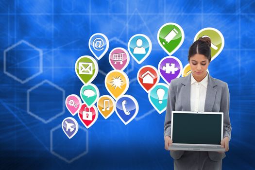 Businesswoman looking at laptop in her hands against abstract technology background