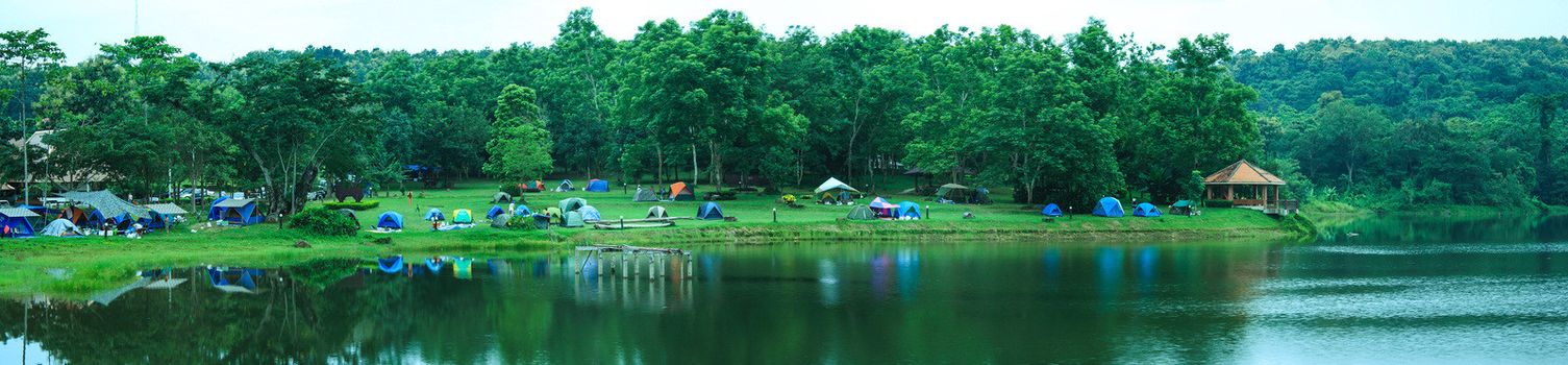 Camp in forest with river and sky