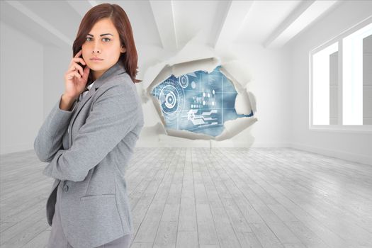 Concentrating businesswoman against rip on wall showing technology interface