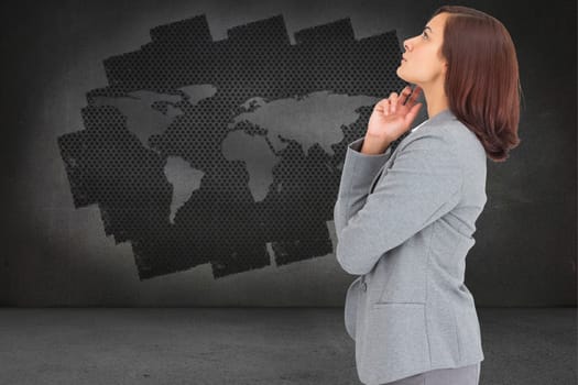 Concentrating businesswoman against display on wall showing global technology graphic