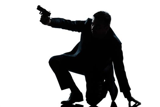 one caucasian spy criminal policeman detective man aiming shooting gun full length silhouette in studio isolated white background