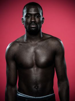 one young handsome african man topless portrait in studio on red background