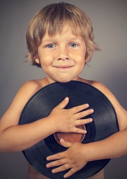 A boy with a record smiles