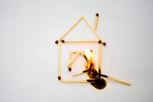 burning match near model of the house