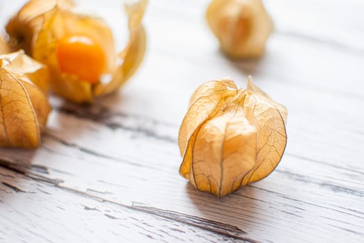 ripe healthy orange physalis over wooden board