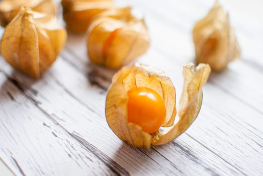 ripe healthy orange physalis over wooden board