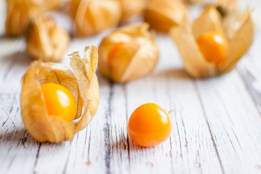 ripe healthy orange physalis over wooden board