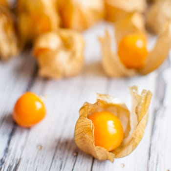 ripe healthy orange physalis over wooden board