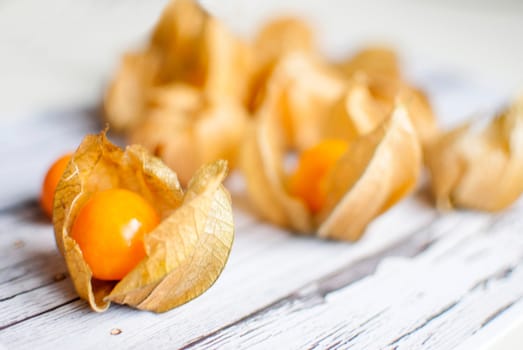 ripe healthy orange physalis over wooden board