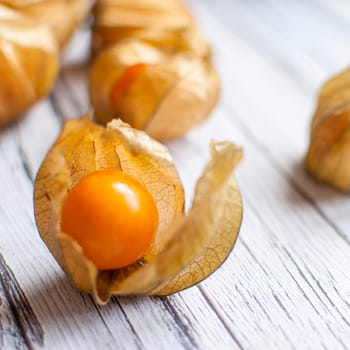 ripe healthy orange physalis over wooden board