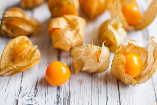 ripe healthy orange physalis over wooden board