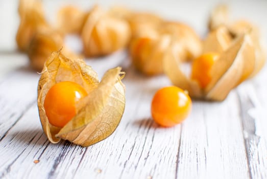 ripe healthy orange physalis over wooden board