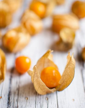 ripe healthy orange physalis over wooden board