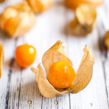 ripe healthy orange physalis over wooden board