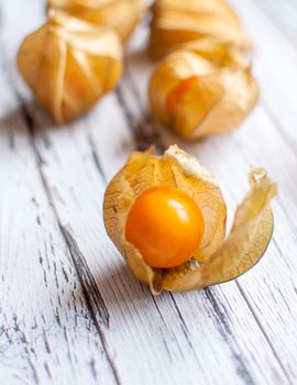 ripe healthy orange physalis over wooden board