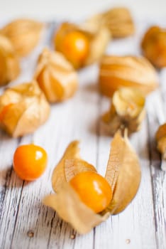 ripe healthy orange physalis over wooden board