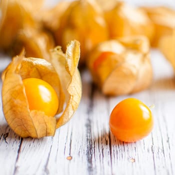 ripe healthy orange physalis over wooden board