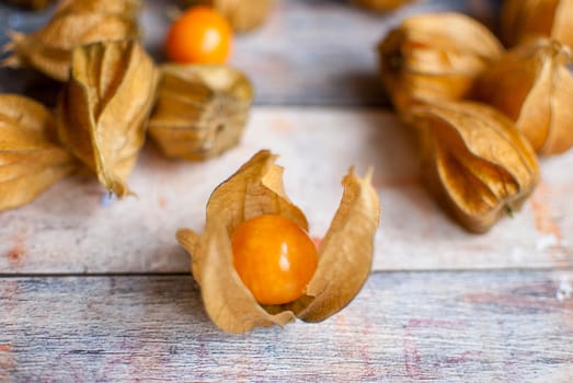 ripe healthy orange physalis over wooden board