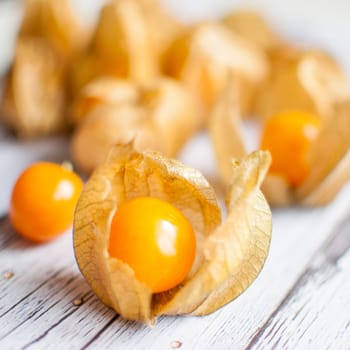 ripe healthy orange physalis over wooden board