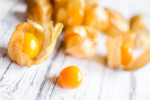 ripe healthy orange physalis over wooden board