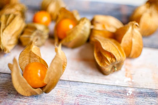 ripe healthy orange physalis over wooden board